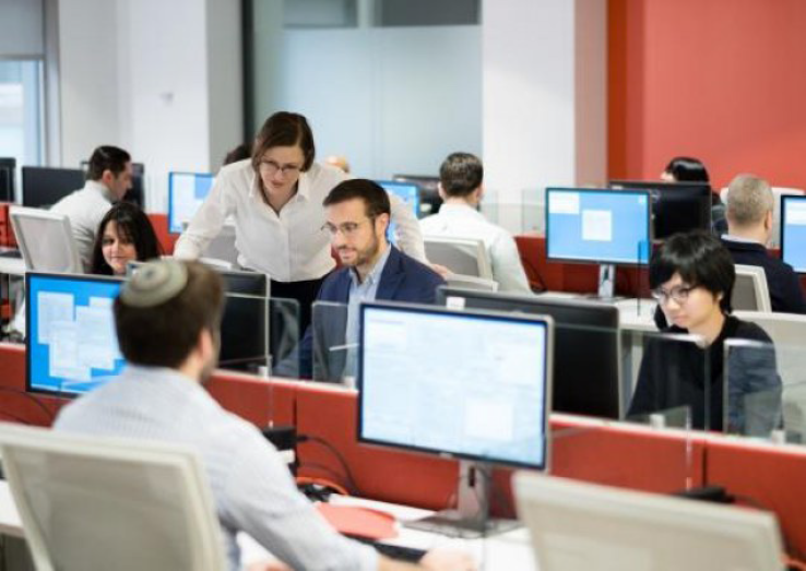 An instructor helping students in a computer class